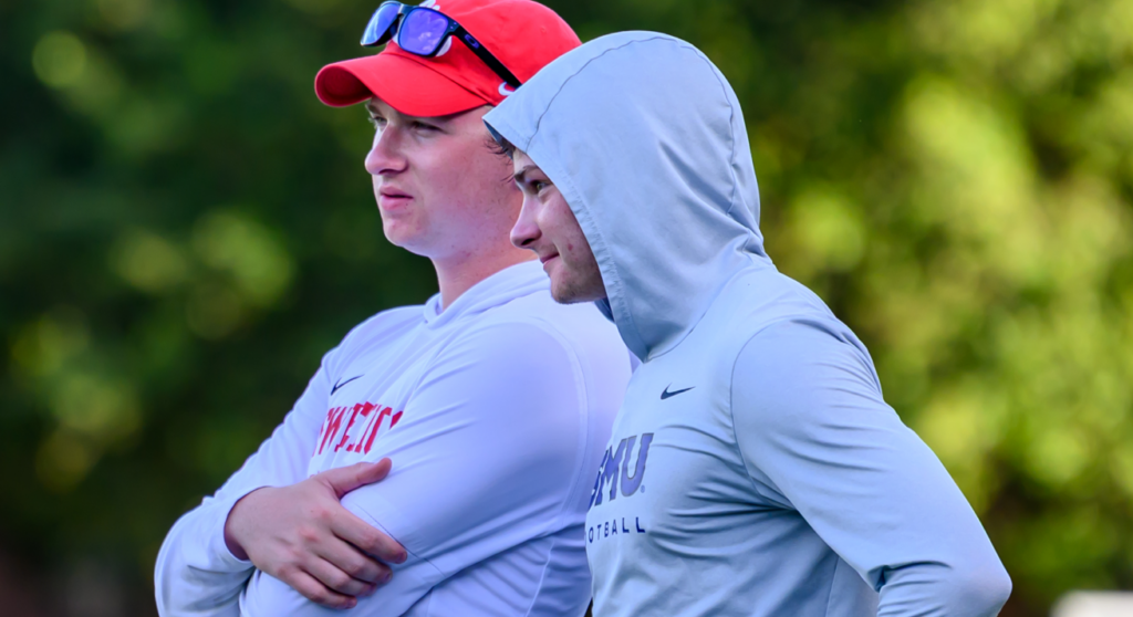 College coaches evaluating athletes at a college sports recruiting camp.