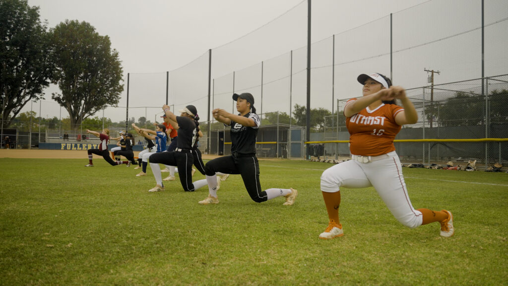 Softball players warming up at an exposure event in recruiting film.