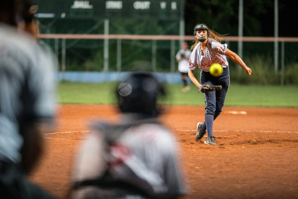 Softball pitcher tracking the ball mid-delivery