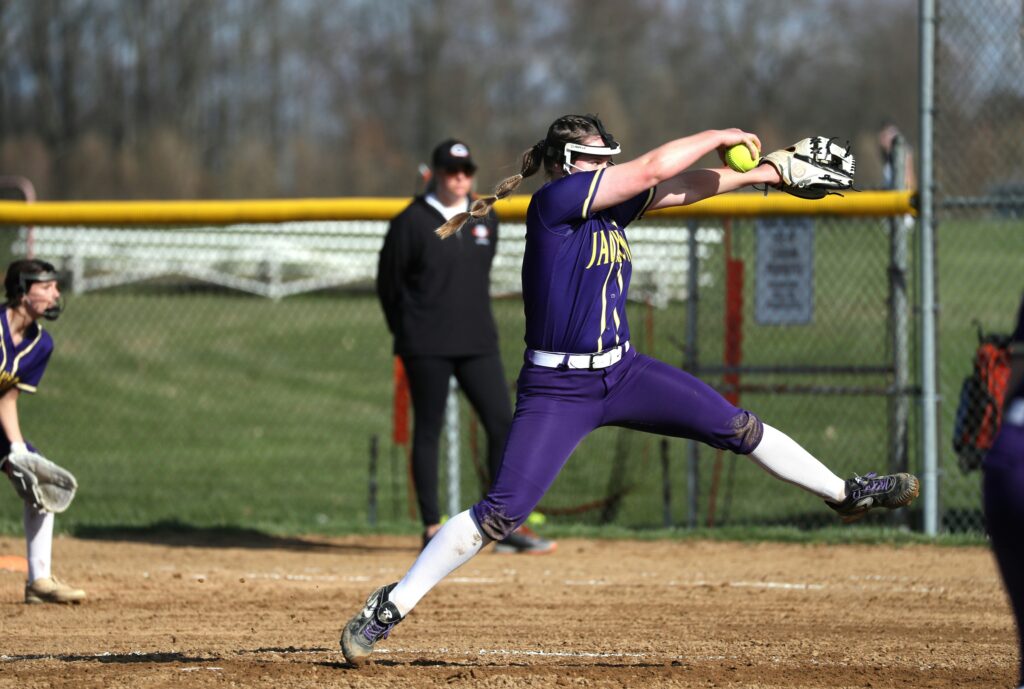 Teenage softball pitcher winding up to throw a fastball