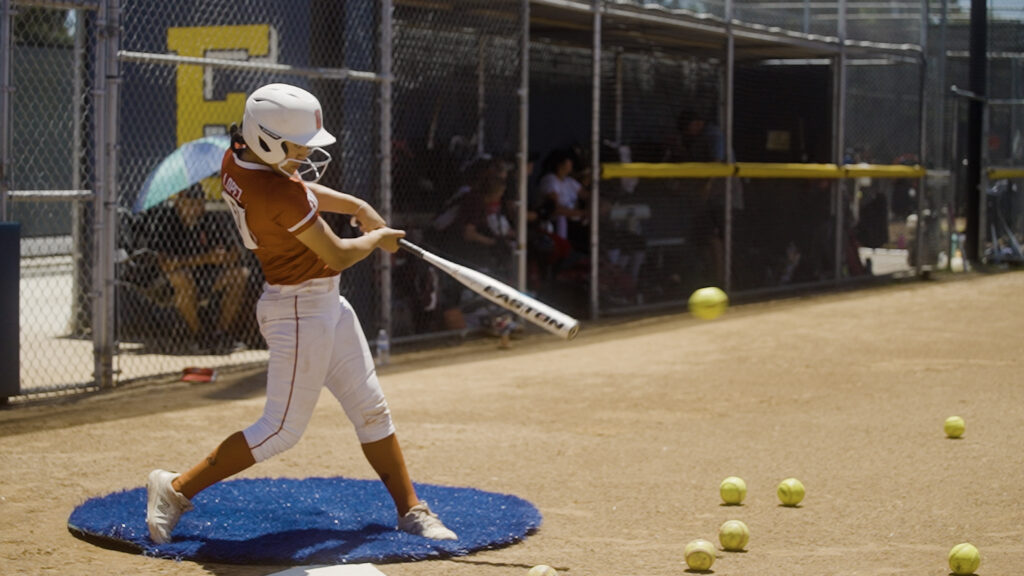 Softball player taking a practice swing on the field